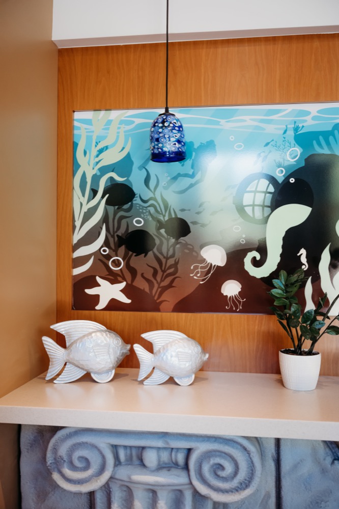 Underwater wall artwork, fish sculptures, and a blue pendant light inside Atlantis